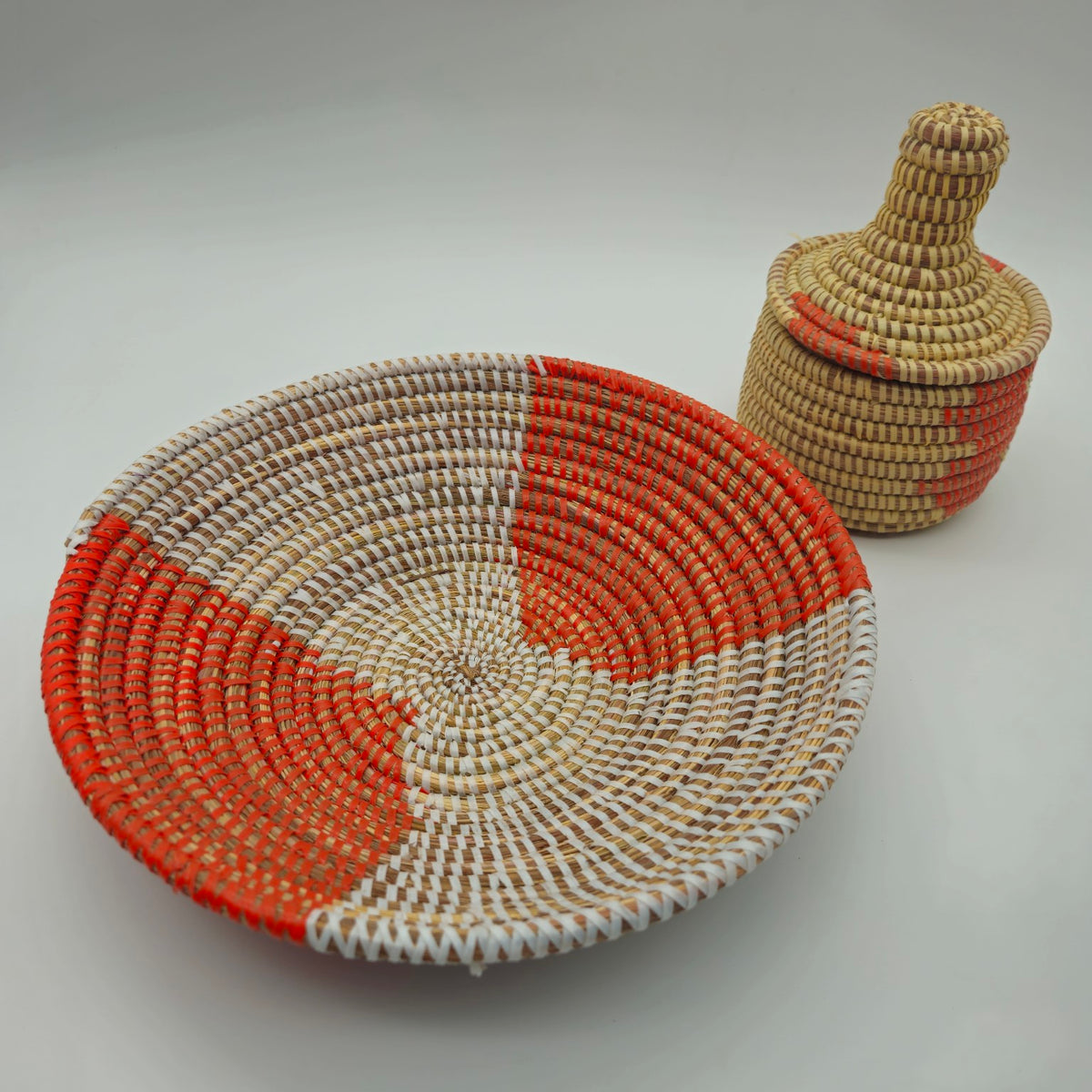 Orange Senegalese handwoven shallow basket with coordinating lidded basket